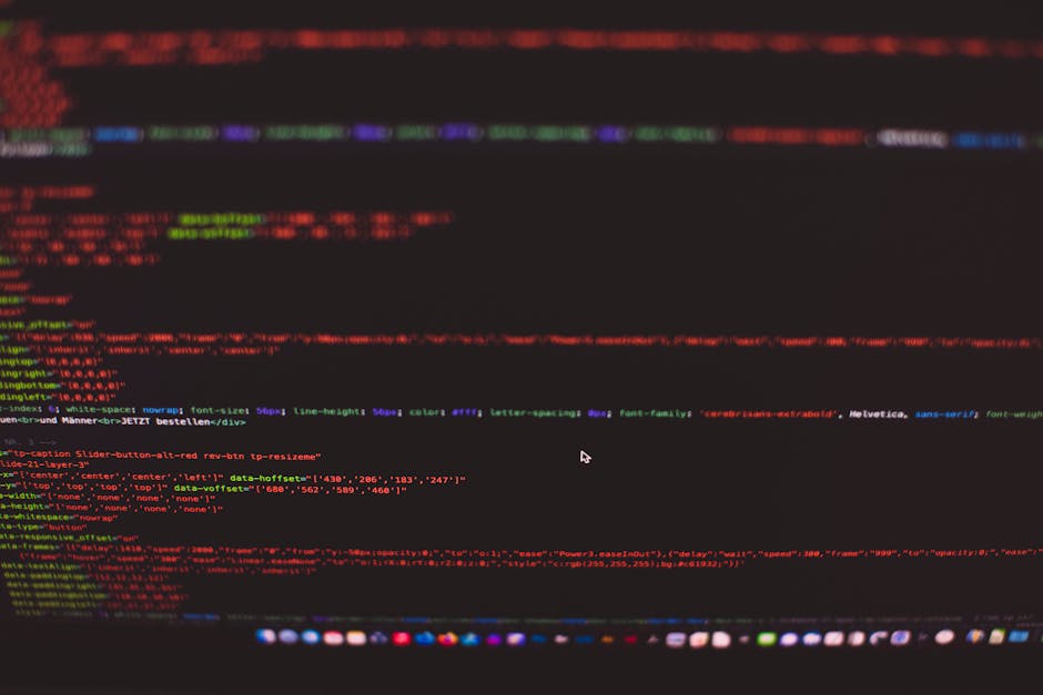 Close-up image of a computer screen displaying lines of HTML code with various tags and attributes in multiple colors including red, yellow, blue, and green on a dark background. The code includes ref